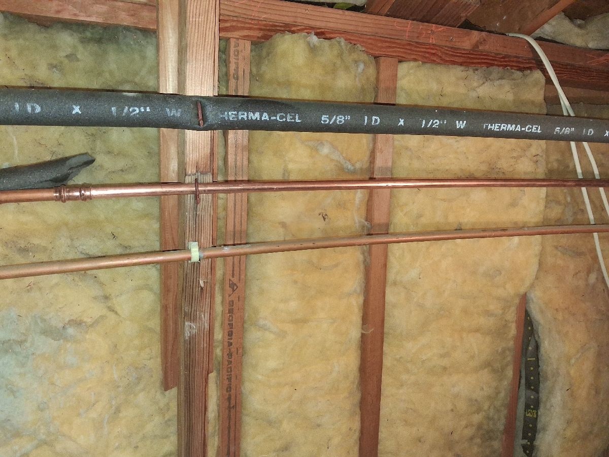 Replacement copper piping photographed through an open ceiling access area